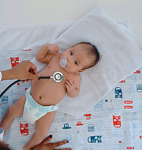 Well baby check where the baby is getting his heart listened to by the doctor.